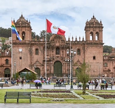 people walking near Cusco Cathedral in Peru under white and blue sky