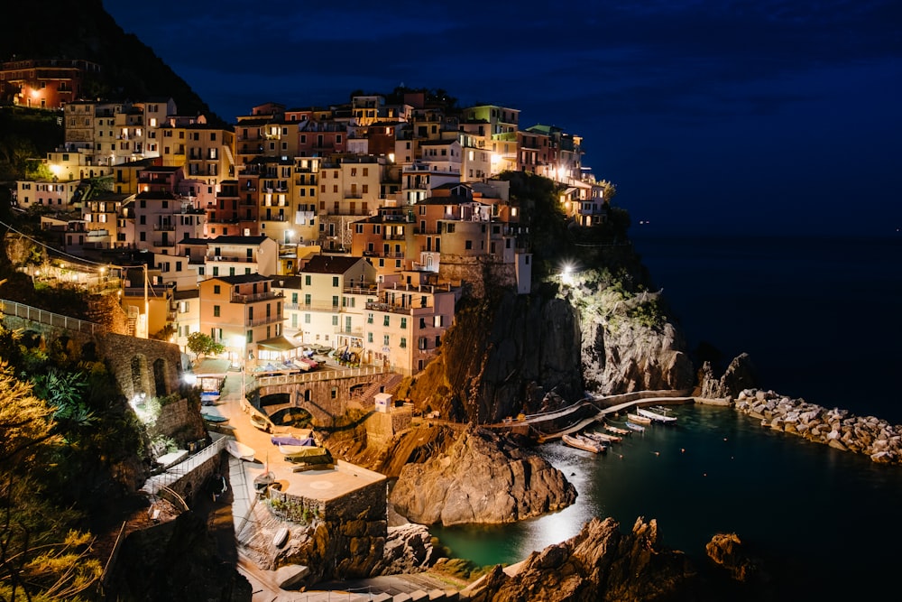 fotografia aerea della città con grattacieli vicino allo specchio d'acqua durante la notte