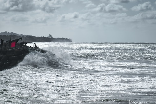 Researchers measuring wave impacts on a rocky shoreline during a storm.