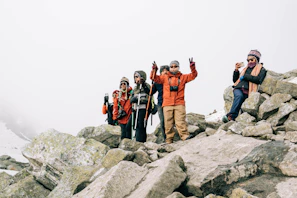 A group photo of happy travelers in warm jackets with Iceland’s rugged landscape behind
