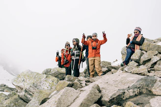 A group photo of happy travelers in warm jackets with Iceland’s rugged landscape behind