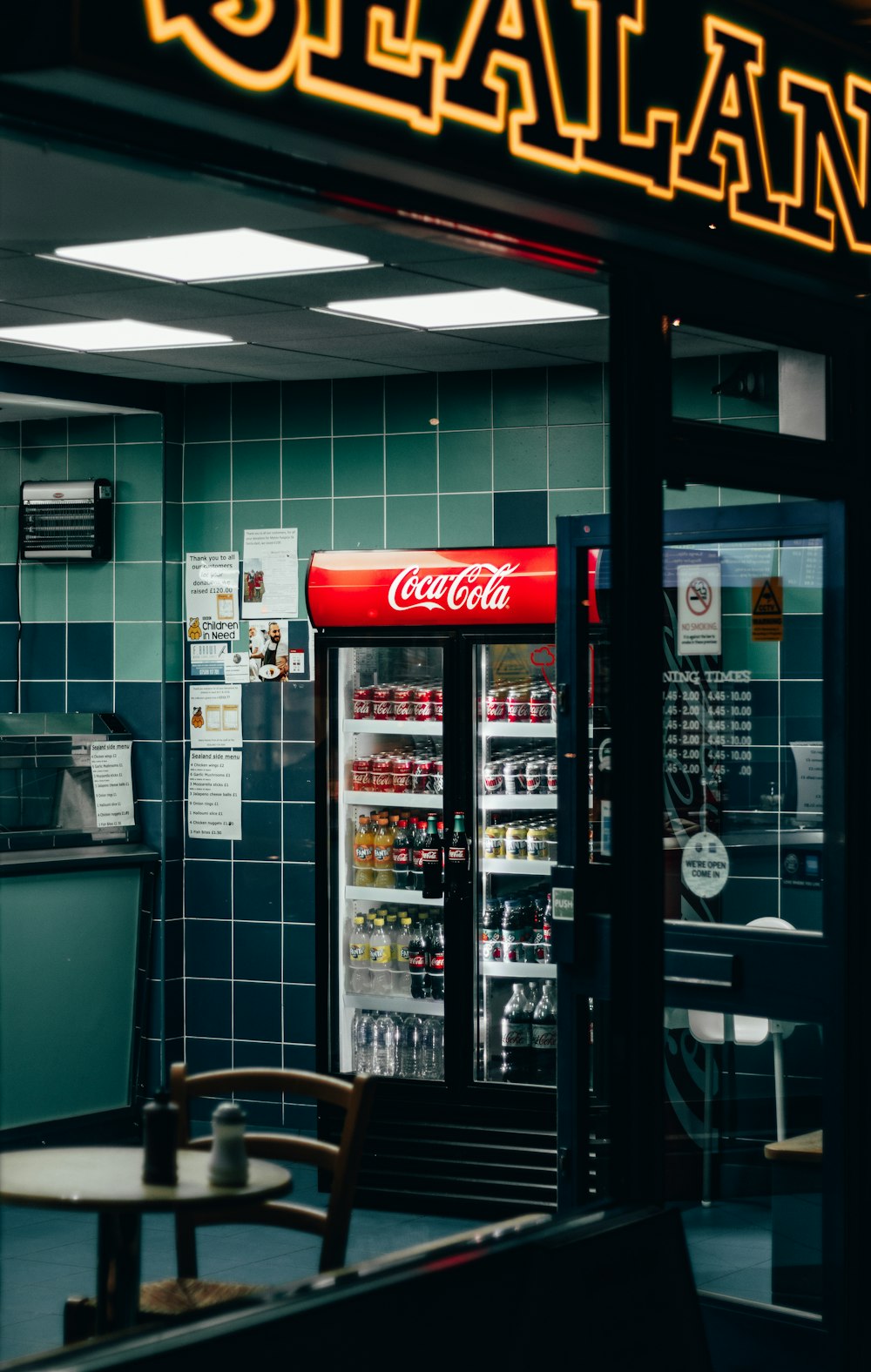 beverages in Coca-Cola beverage cooler inside shop during night