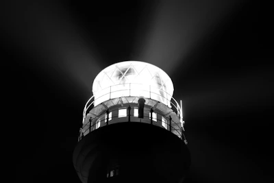 A sleek modern lighthouse shining light over turbulent seas representing guidance.