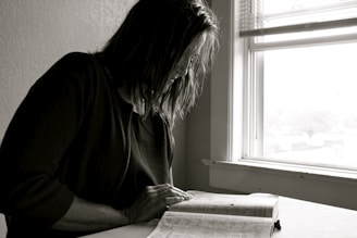 A serene portrait of a person reading a psychology book in natural light.