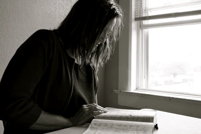 A person reading a book in a quiet, sunlit corner, emphasizing focused learning.