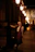 A peaceful street scene at dusk with a person leaning against a lamppost, eyes closed, immersed in sound.