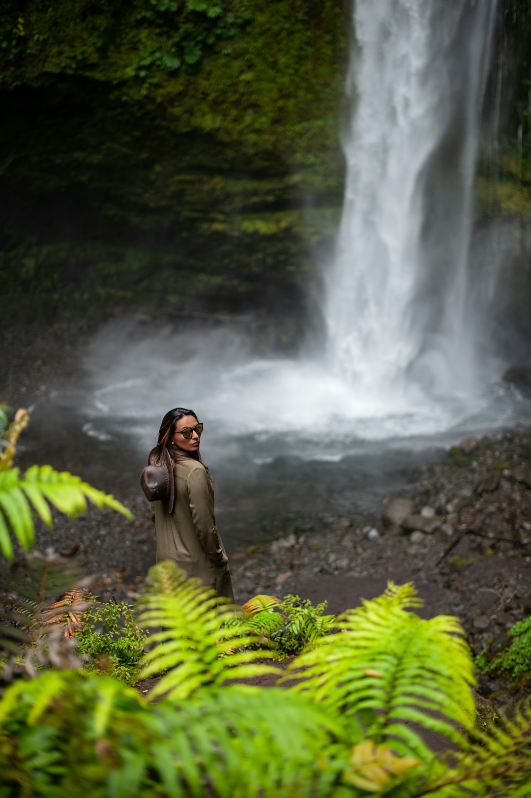 woman standing in front of waterfalls during daytime