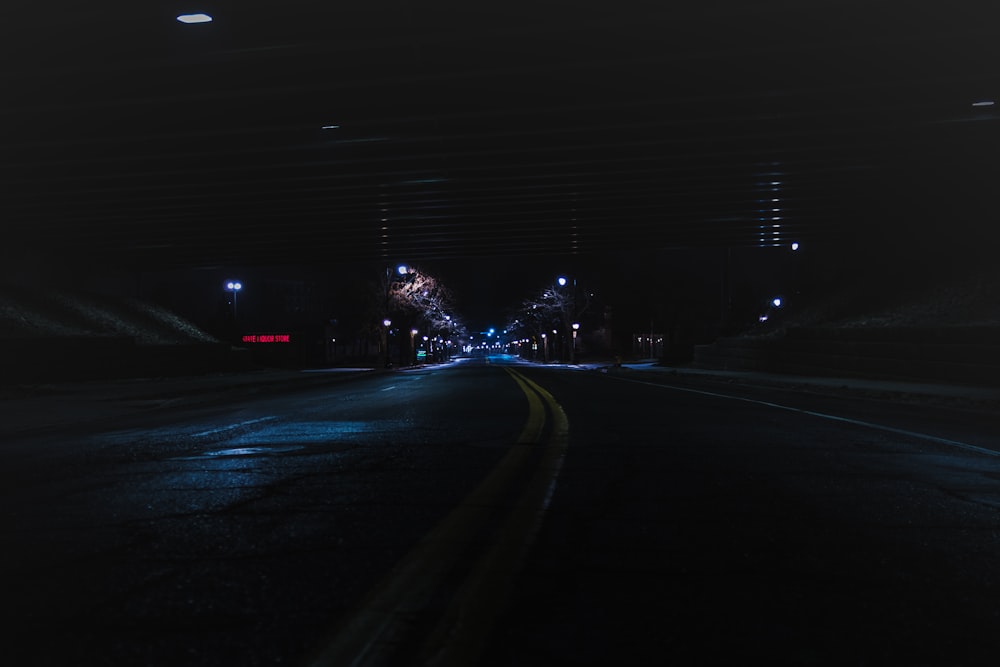 uma rua vazia à noite com luzes acesas