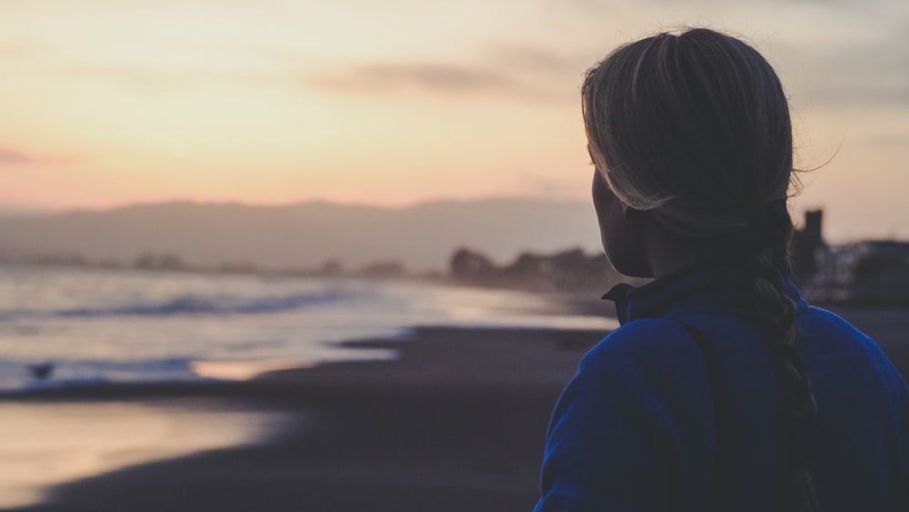 close-up photography of person facing on seashore during daytime