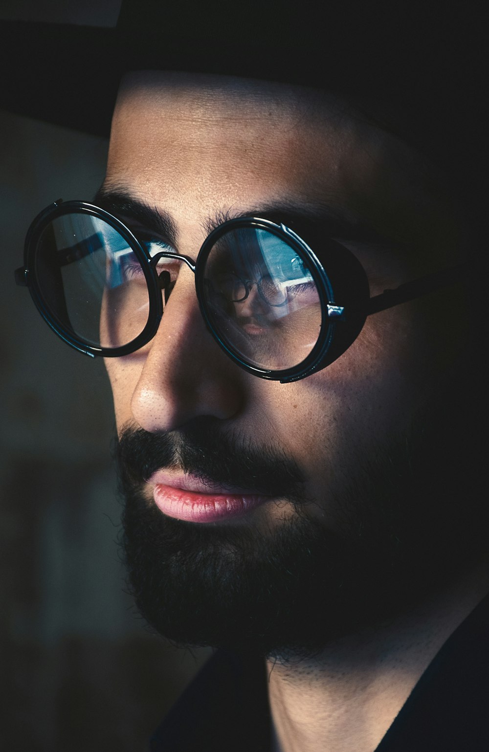 검은 프레임 안경을 쓴 남자의 선택적 초점 사진