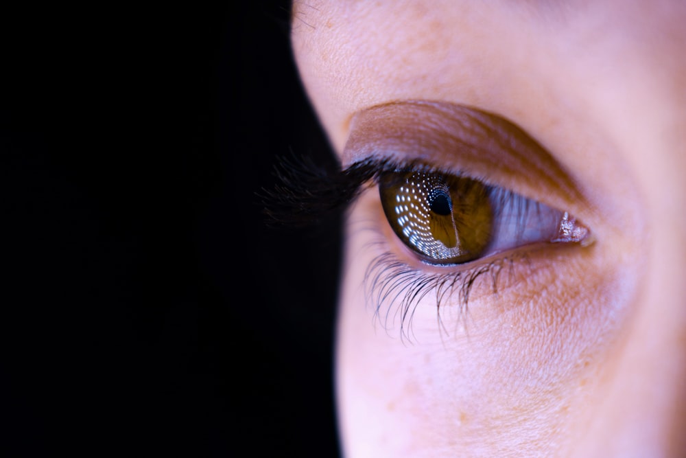 a close up of a person's eye with a black background