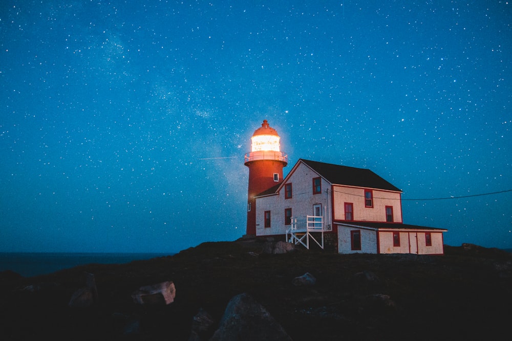 white wooden house beside lighthouse