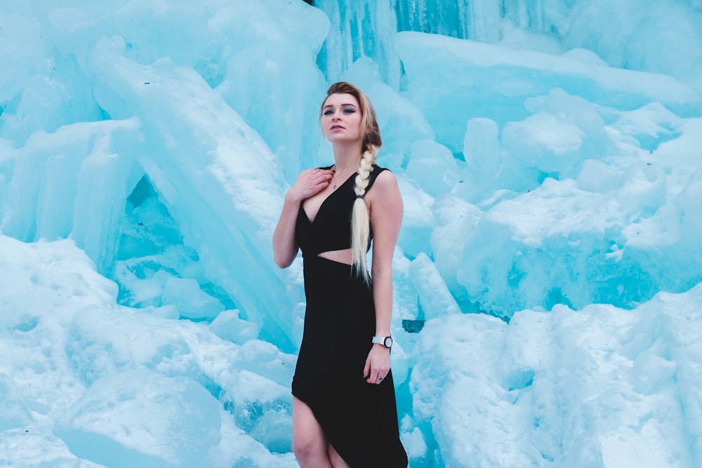 woman in black dress standing near ice glaciers