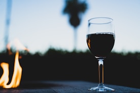 clear wine glass with red wine on table