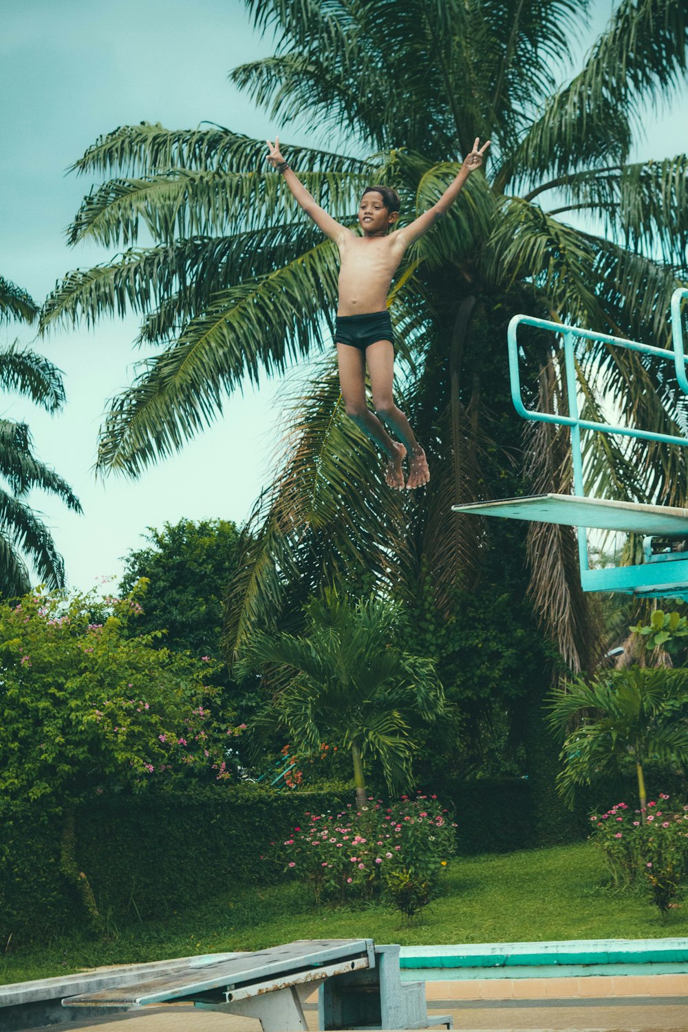 boy jumping on swimming pool