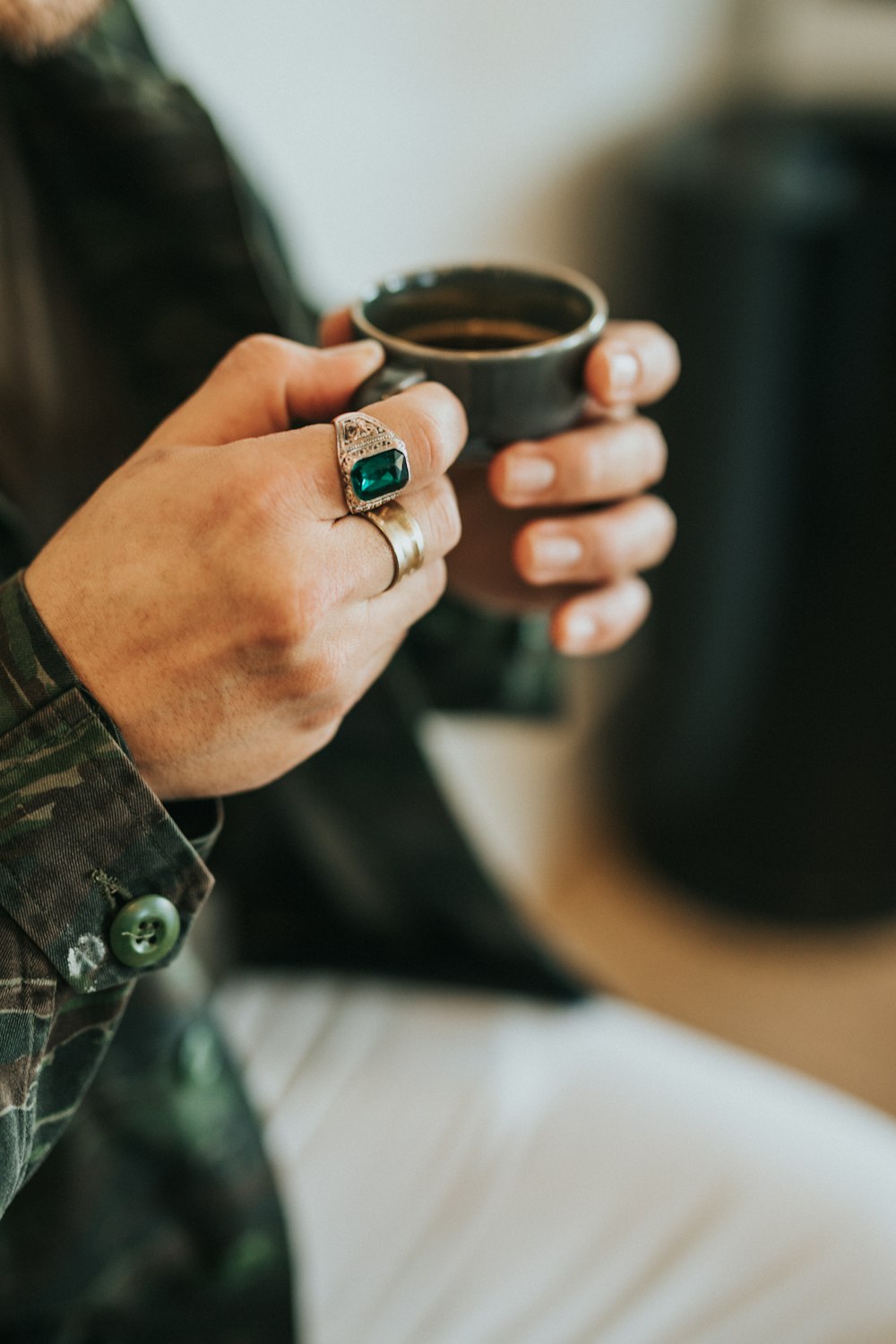 person holding gray teacup