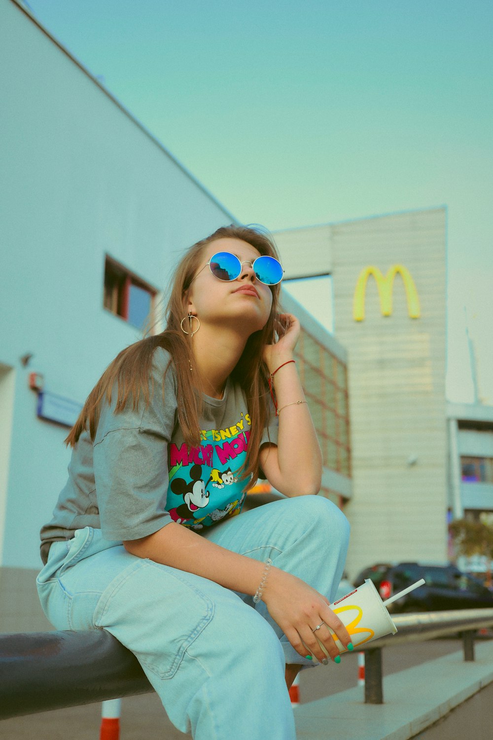 woman wearing grey shirt and blue sunglasses taking selfie