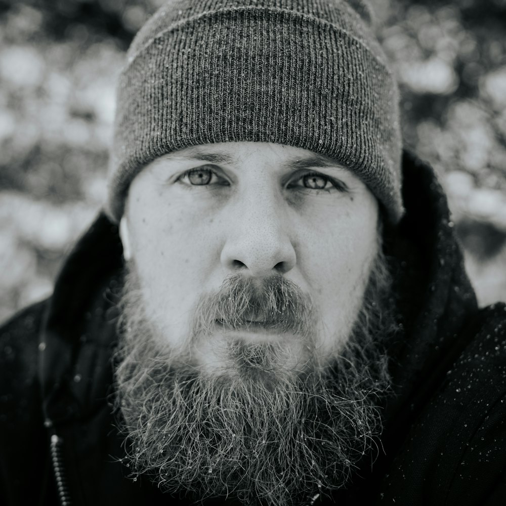 grayscale photography of man jacket and knit cap