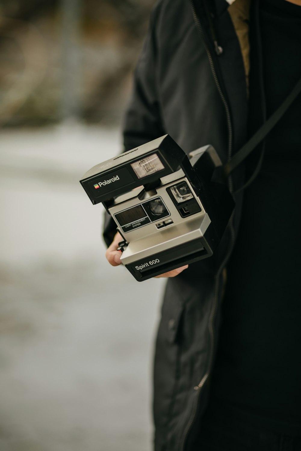 selective focus photography of person holding gray and black camera