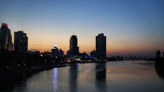 A calm industrial skyline at dusk with soft blue lighting highlighting key infrastructure elements.
