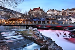 a river flowing under a bridge next to a tall building