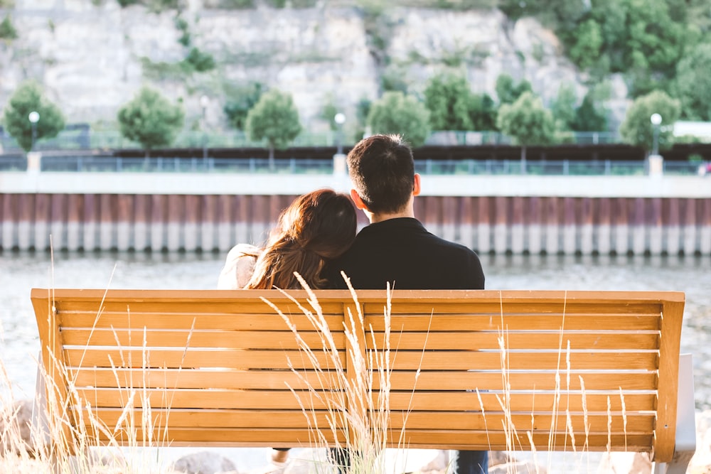 couple sitting on wooden bench