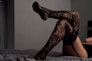 lying down person wearing black thigh-high socks