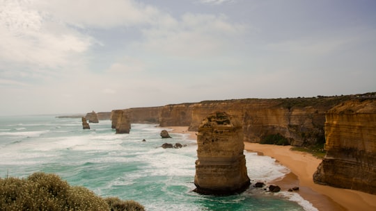 brown cliff beside ocean during daytime in Port Campbell National Park Australia