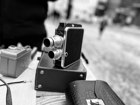 Vintage camera with leather case displayed on a rustic wooden table
