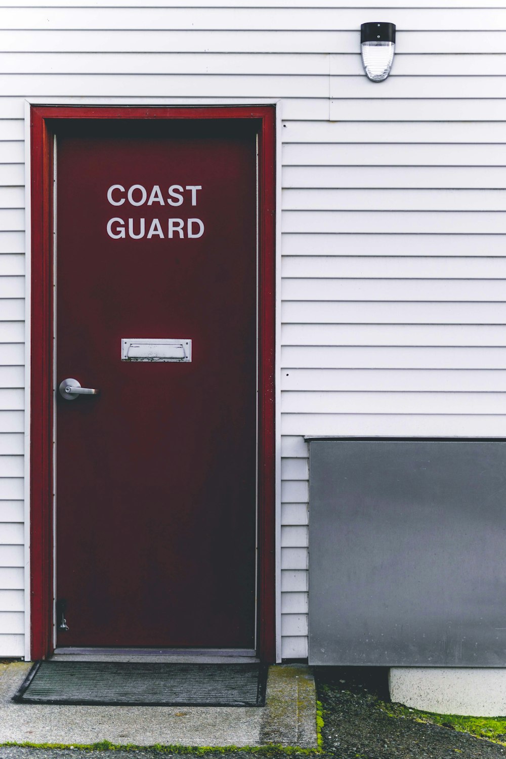 closed red and white Coast Guard wooden door