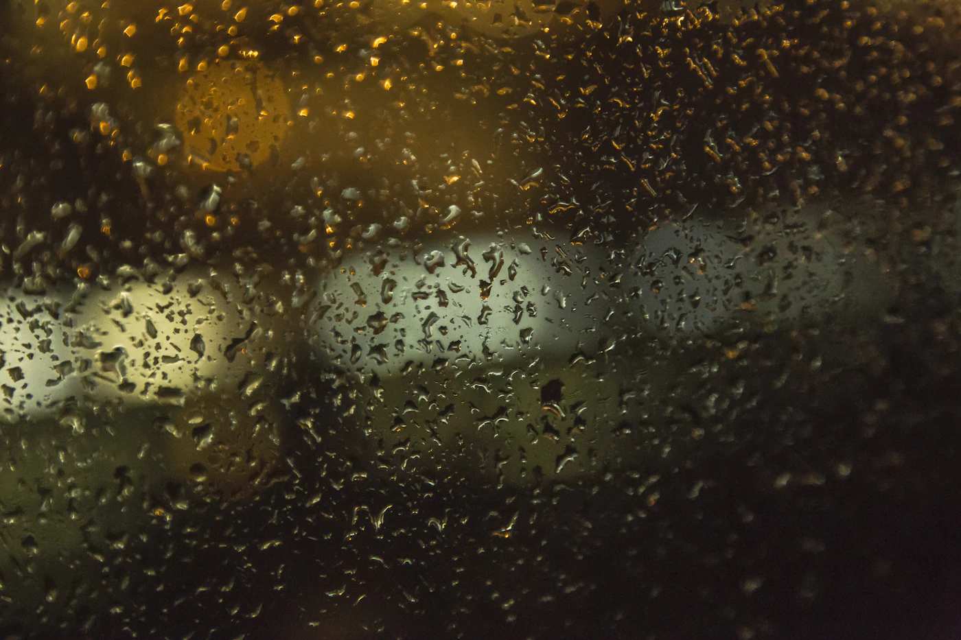 ガラスにつく雨粒とぼんやりした街灯