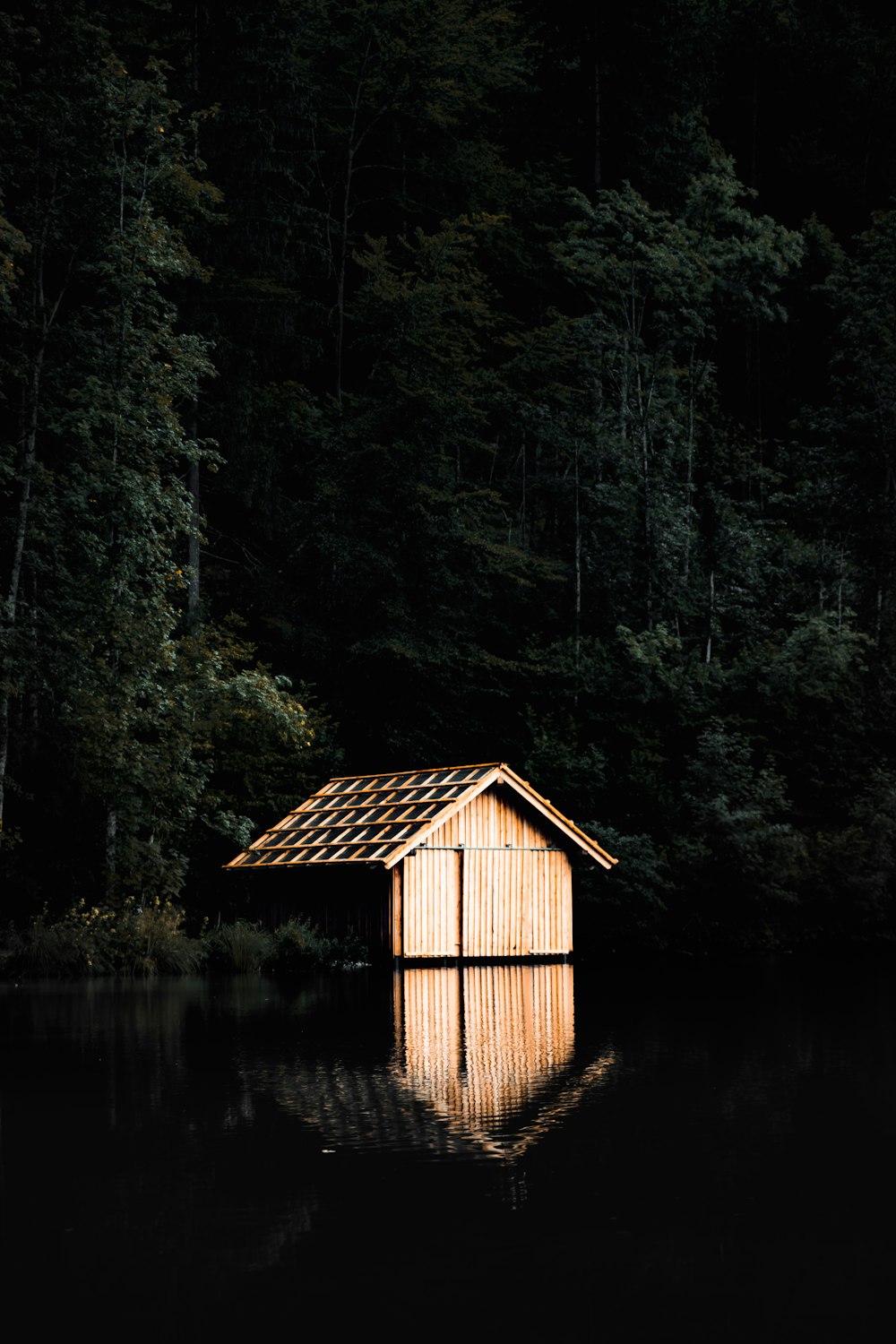 湖の近くの茶色の木造キャビン