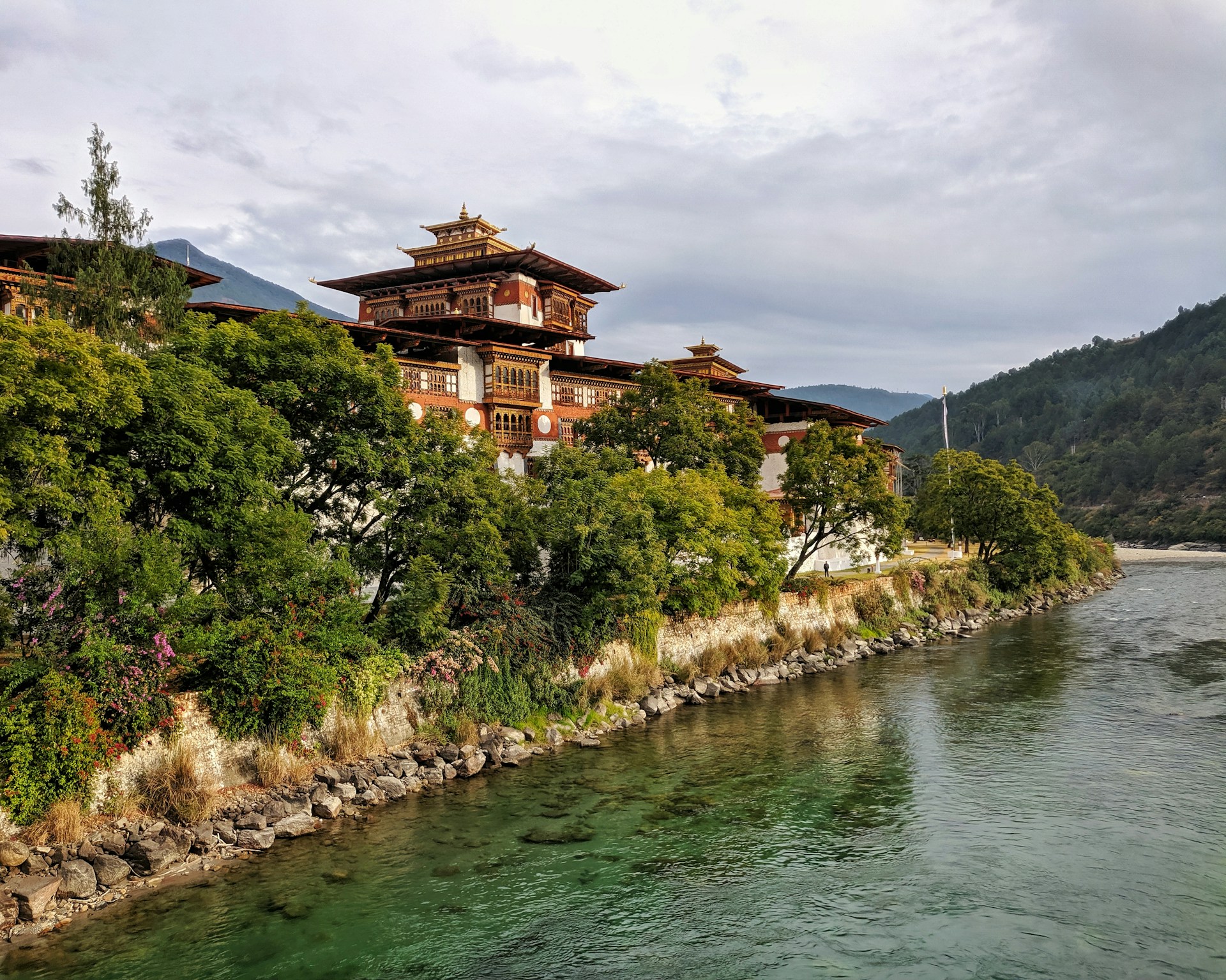 temple surrounded with trees facing body of water
