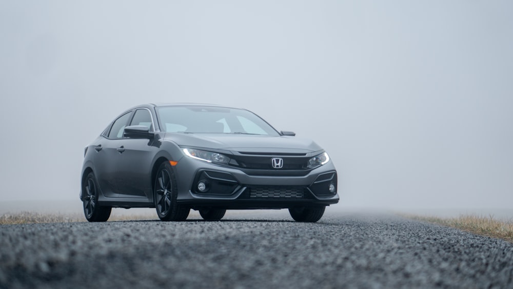 Sedán Honda gris estacionado en la carretera durante el día