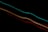 Bright, colorful light trails streak diagonally across a black background, creating a sense of motion and energy.
