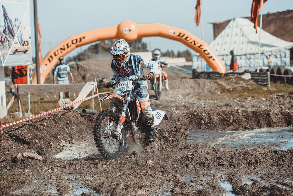time-lapse photography of man riding a motocross in a muddy road