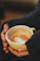 Close-up of a happy customer holding a steaming cup of coffee from Hatana Coffee.