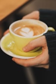 A close-up of hands holding a cacao cup with steam.