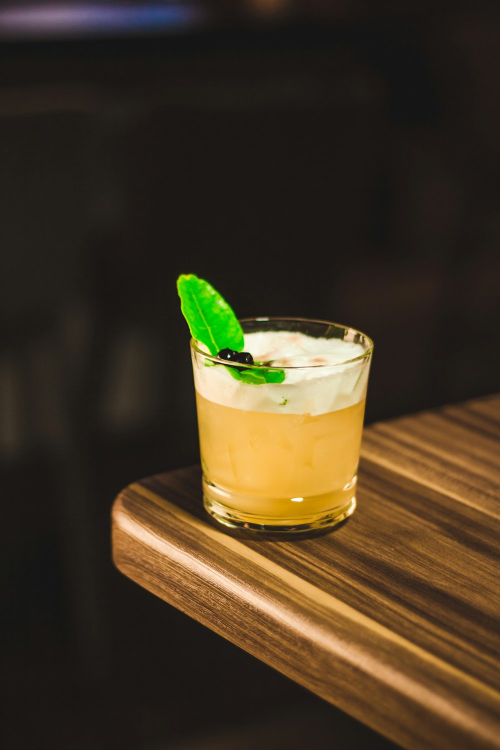 cocktail drink in drinking glass on corner of wooden table