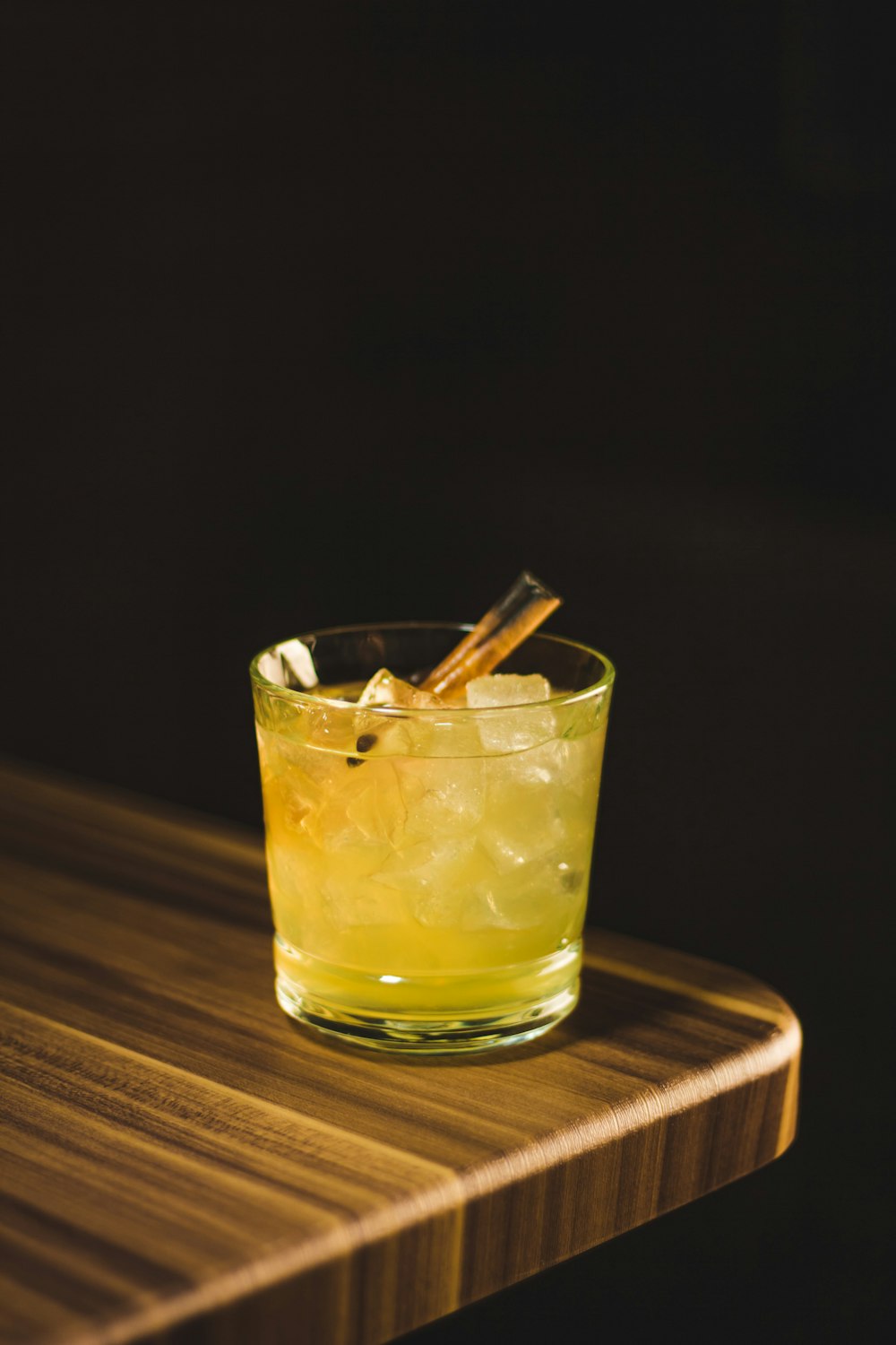 full drinking glass on edge of wooden table