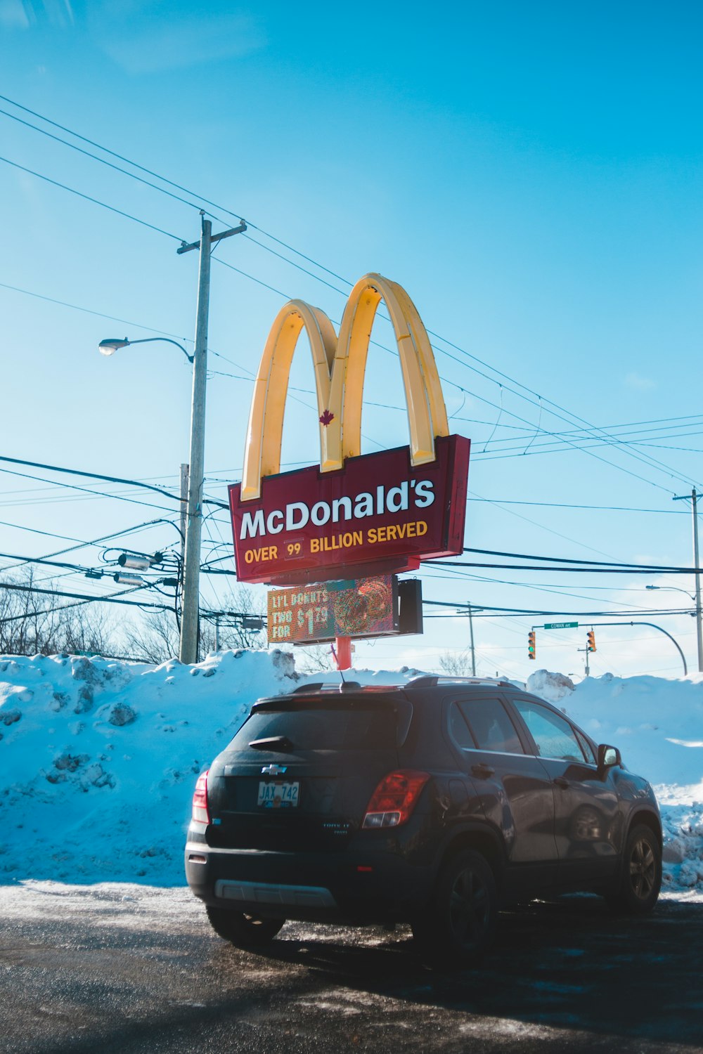 black Chevrolet SUV parked beside McDonald's signage during winter and day