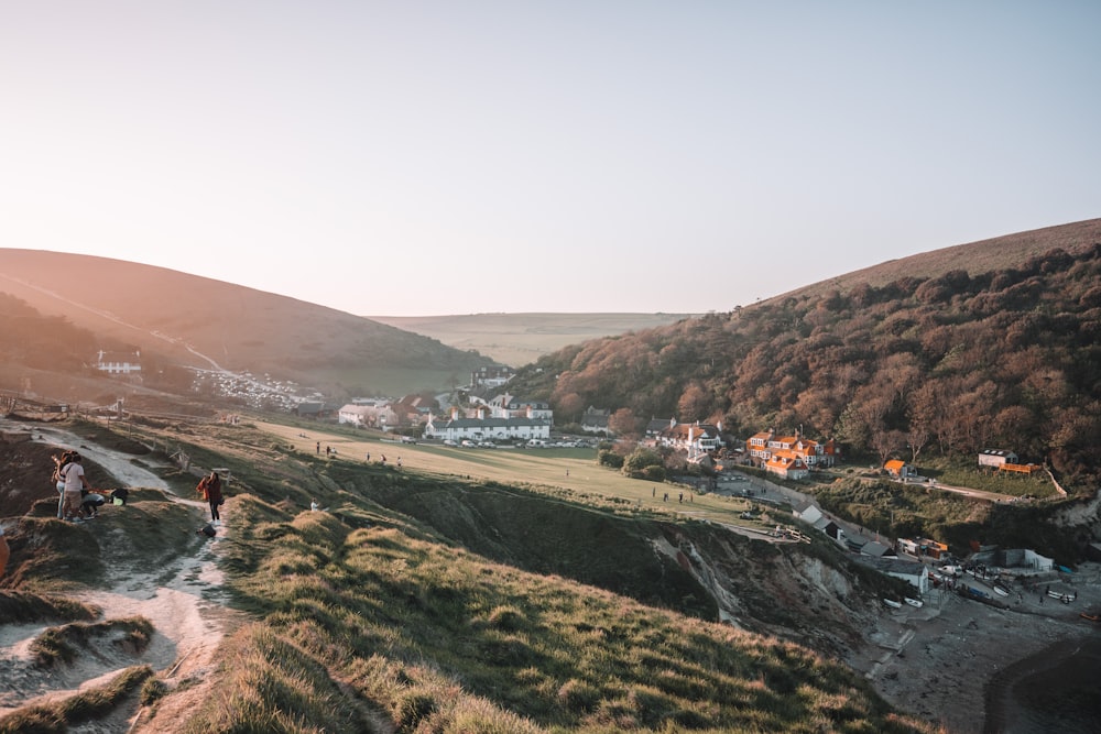 landscape photography of houses on green field viewing mountain during daytime