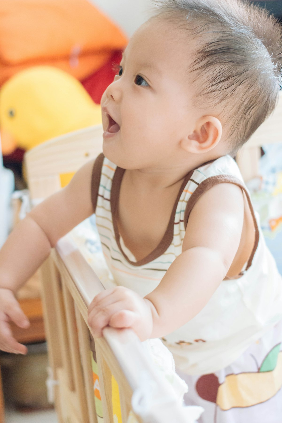 Independent play ideas for a 6-12 month old - baby standing at a playpen rail