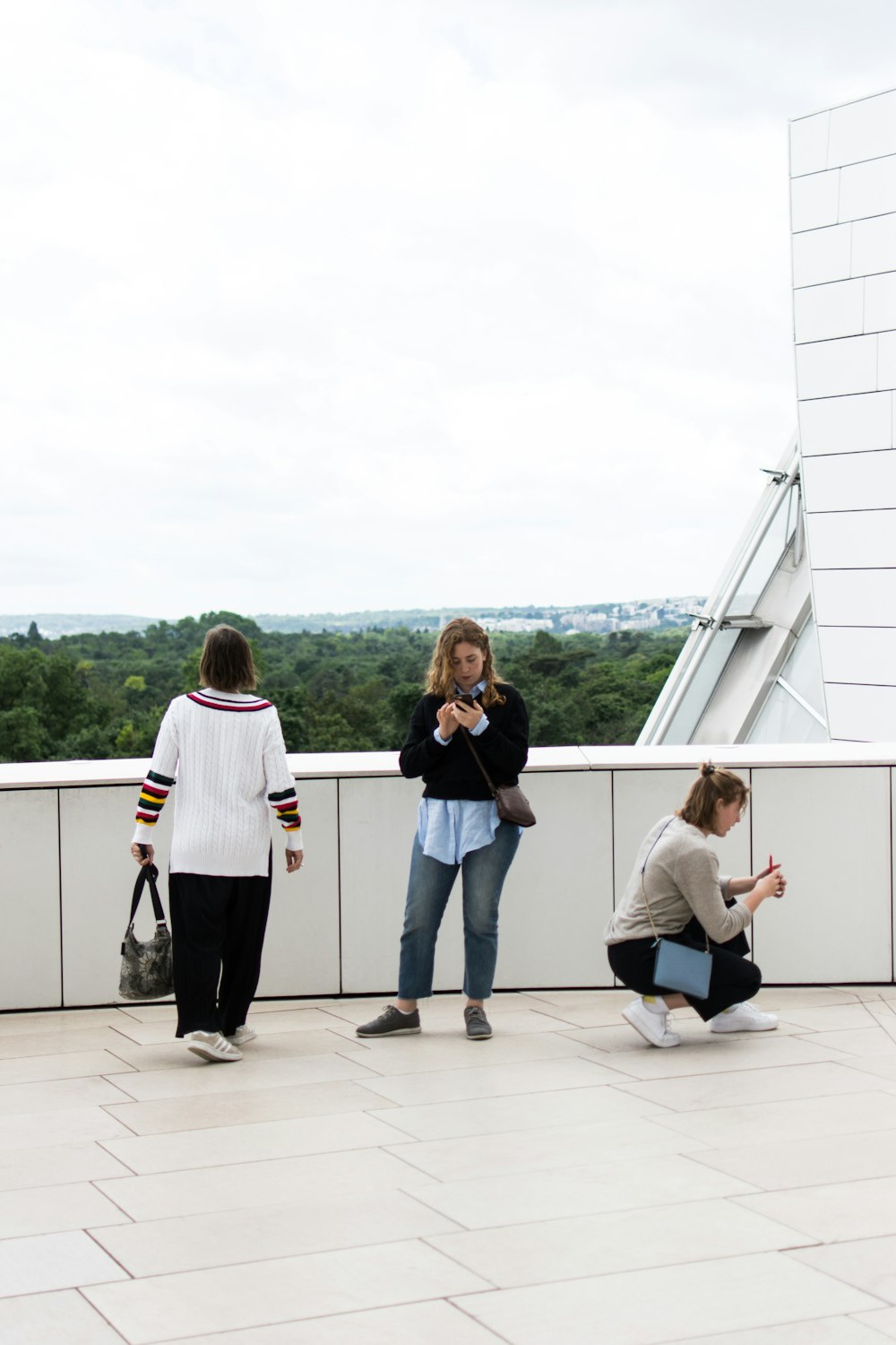 콘크리트 표면에 서서 앉아있는 세 명의 여성