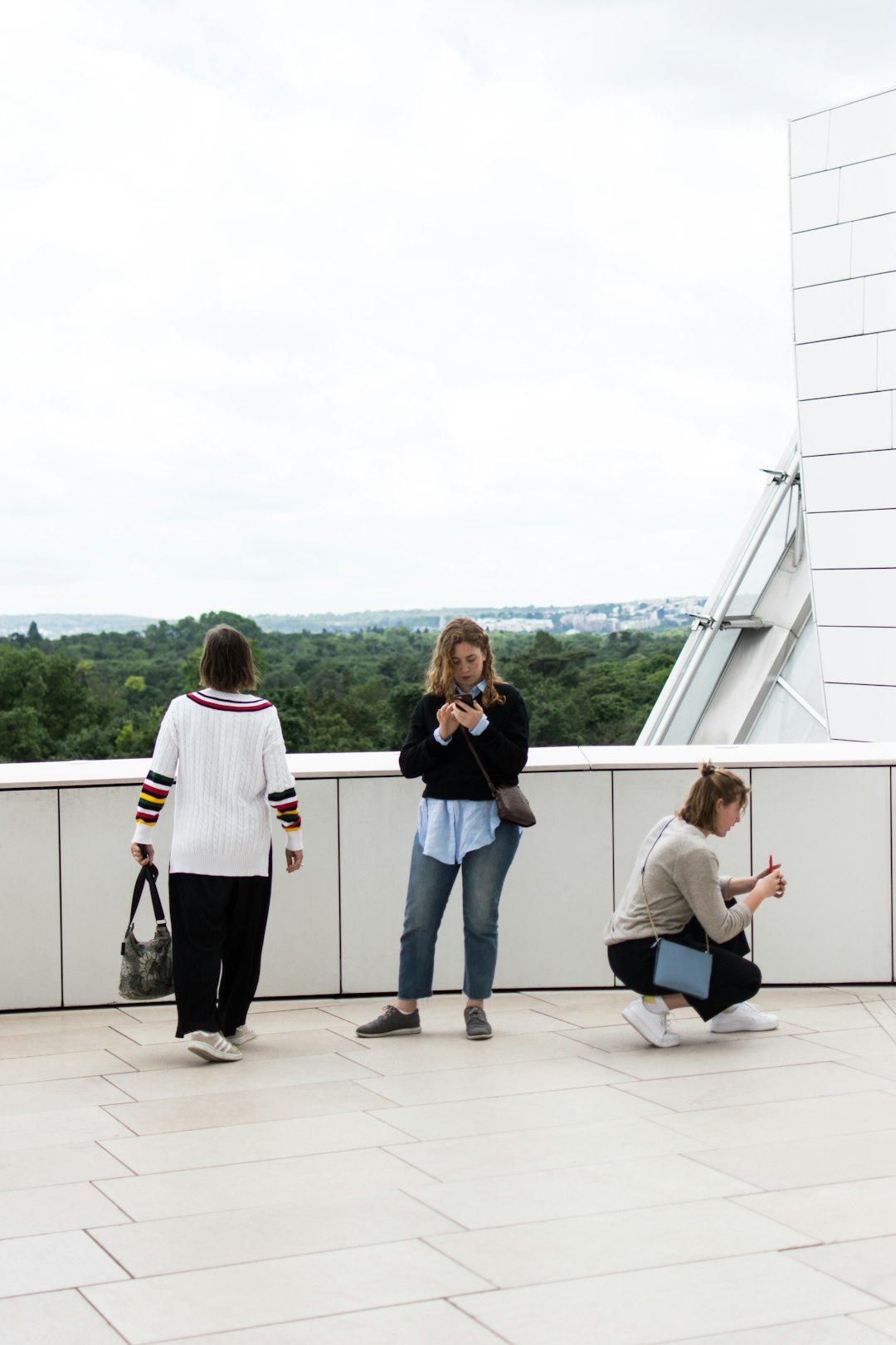 three women on standing and sitting on concrete surface