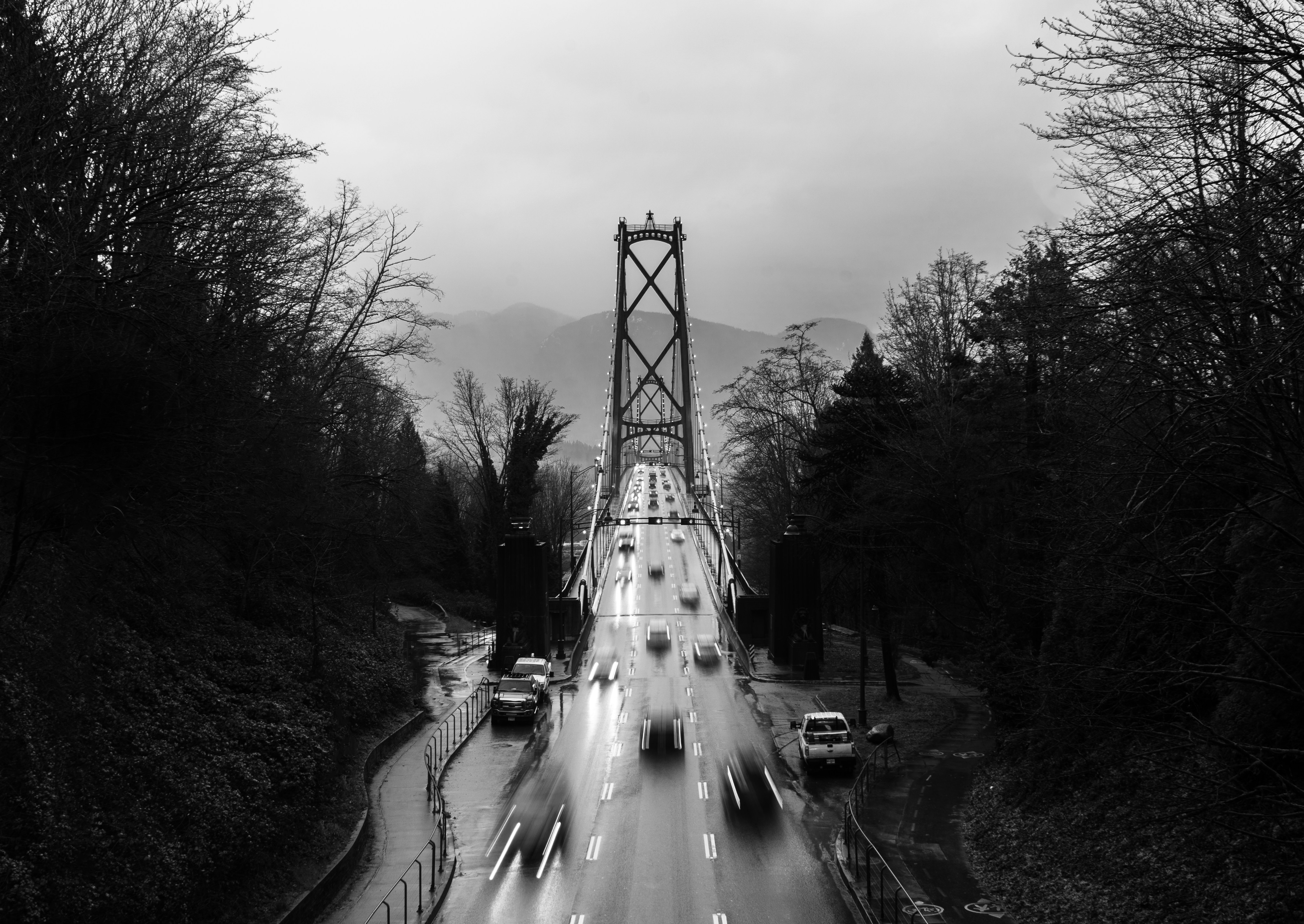 grayscale photography of different vehicles on Lions gate bridge viewing mountain