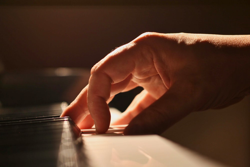 a close up of a person's hand on a piano