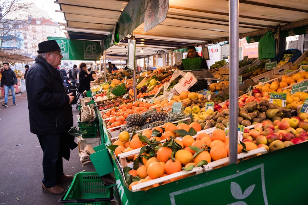 a man standing in front of a fruit stand