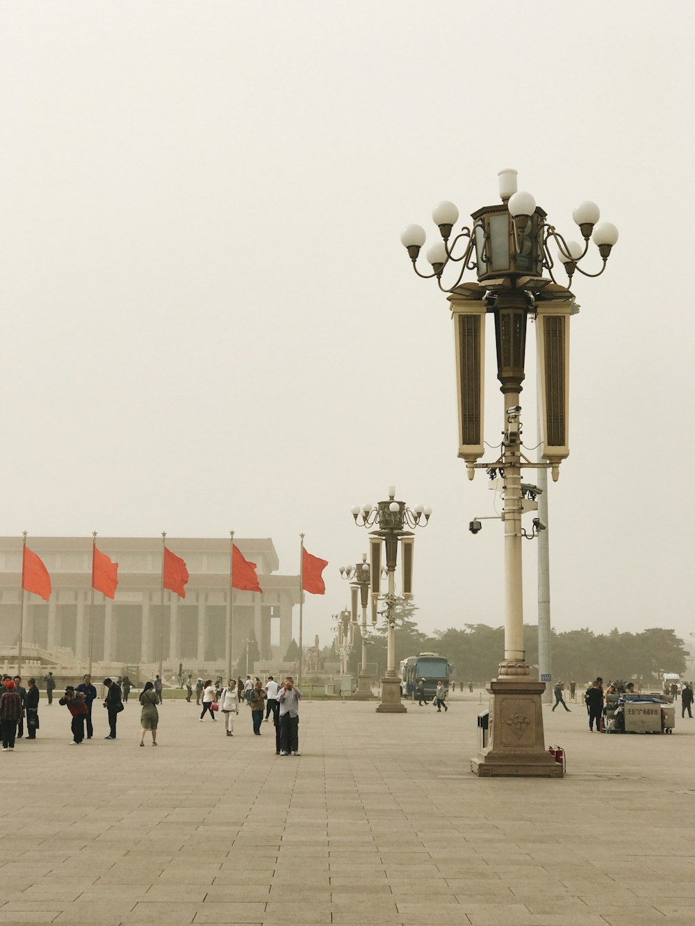 people near lampposts and flags during day