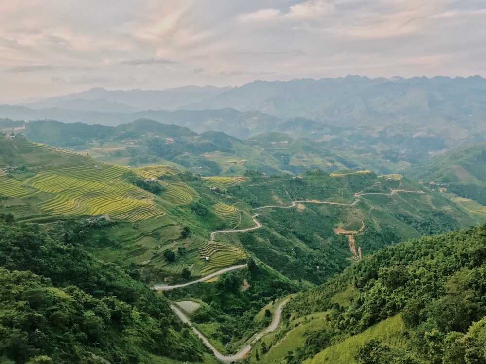 a scenic view of a valley with a winding road